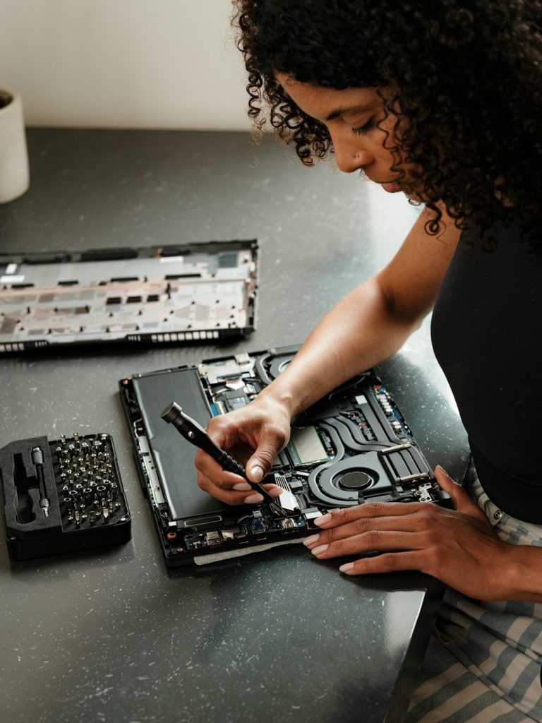 SSD Ausbau bei Attingo Eine Technikerin arbeitet an einem Laptop und verwendet Werkzeuge zum Ausbau der SSD.